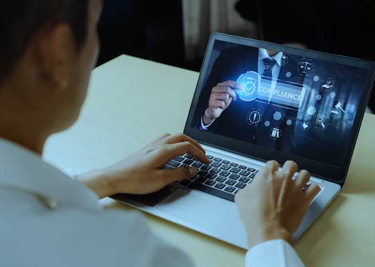 Man Studying Credit Risk Models on a Laptop Displaying Compliance Graphics