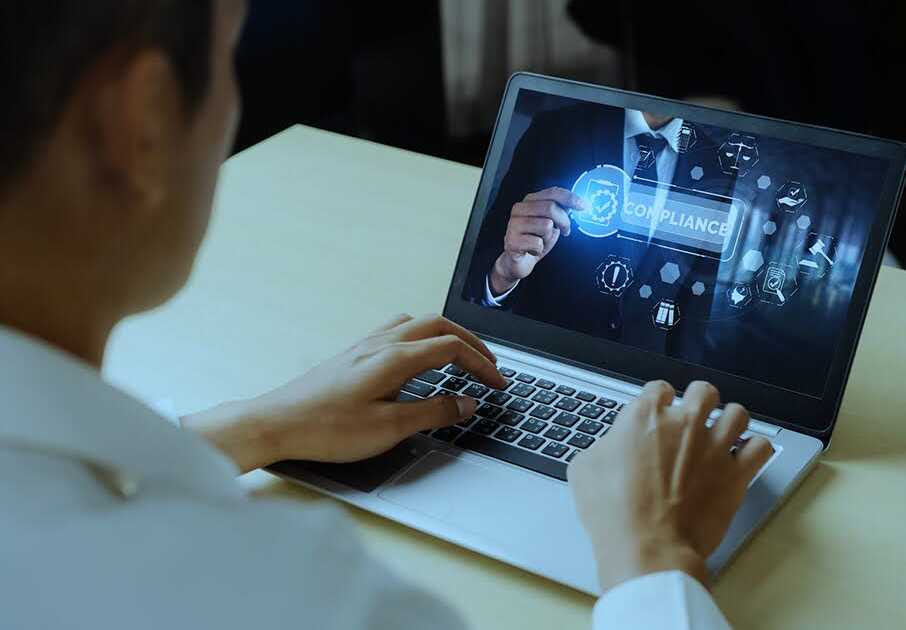 Man Studying Credit Risk Models on a Laptop Displaying Compliance Graphics